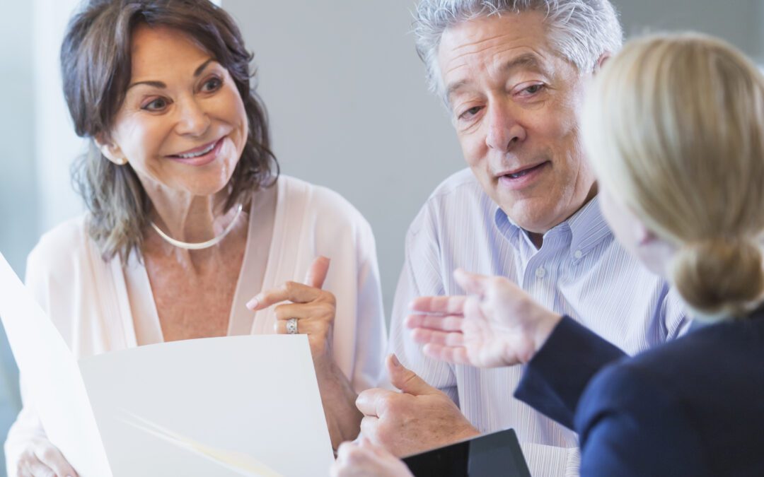 A senior couple sitting down with a financial advisor to discuss their retirement plan.